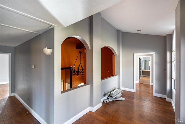 hall featuring hardwood / wood-style floors, a chandelier, and vaulted ceiling