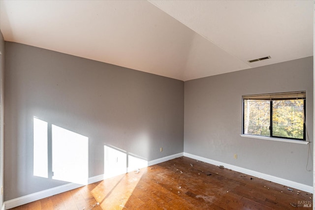 empty room with wood-type flooring and lofted ceiling