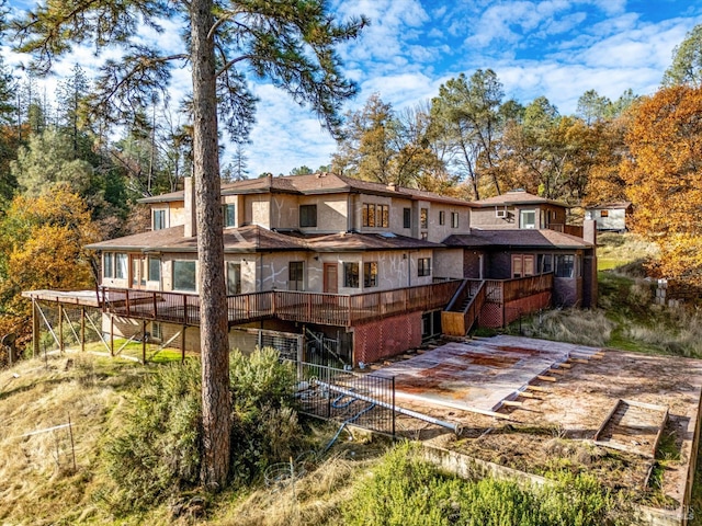 back of house featuring a deck and a patio area