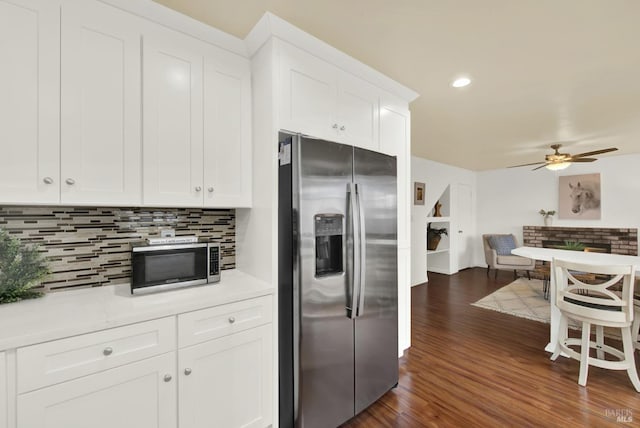 kitchen with tasteful backsplash, stainless steel appliances, ceiling fan, white cabinets, and dark hardwood / wood-style floors