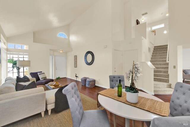 living room with hardwood / wood-style flooring and high vaulted ceiling