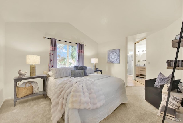 bedroom featuring light carpet, connected bathroom, and lofted ceiling