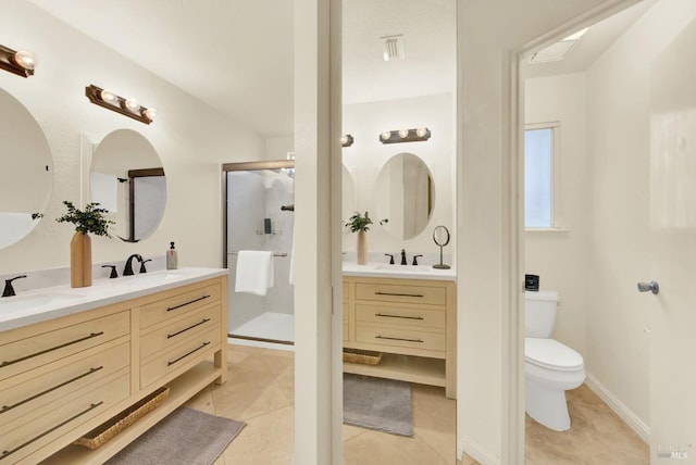 bathroom featuring tile patterned floors, vanity, toilet, and a shower with shower door