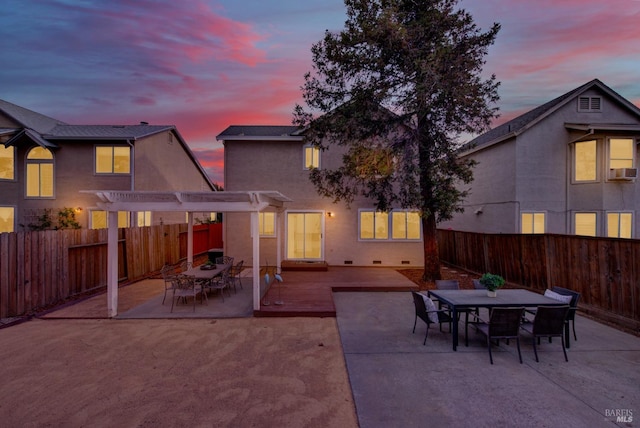 patio terrace at dusk with a pergola and a deck