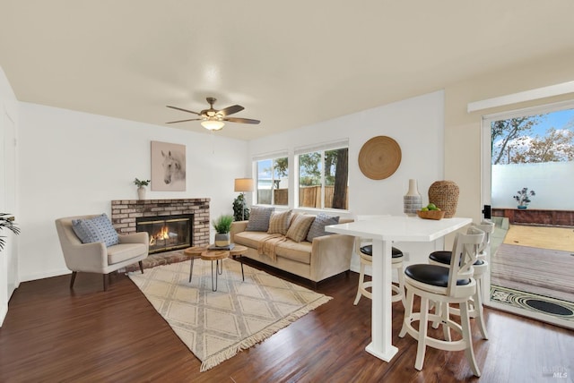 living room featuring ceiling fan, a fireplace, and dark hardwood / wood-style floors