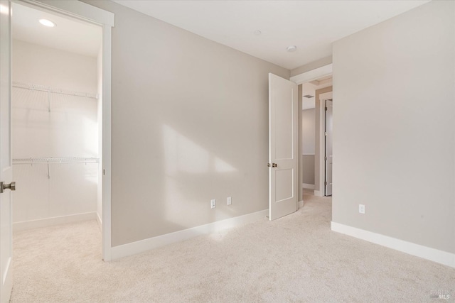 unfurnished bedroom with light carpet and a closet