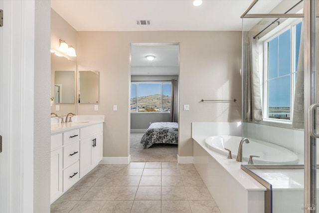 bathroom with a shower stall, tile patterned floors, baseboards, a bath, and vanity