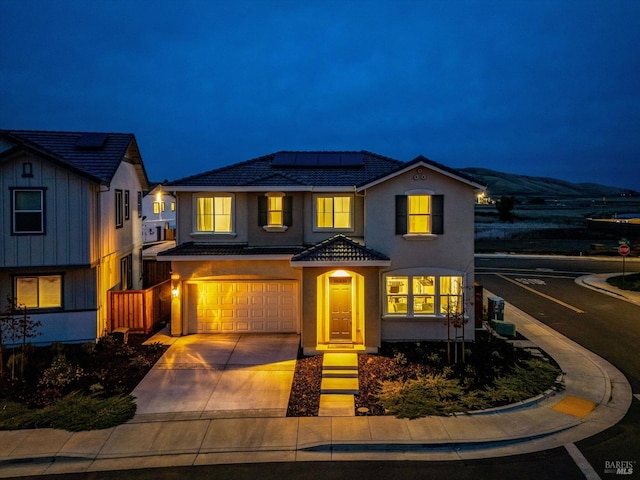 view of front of house with a mountain view, solar panels, and a garage