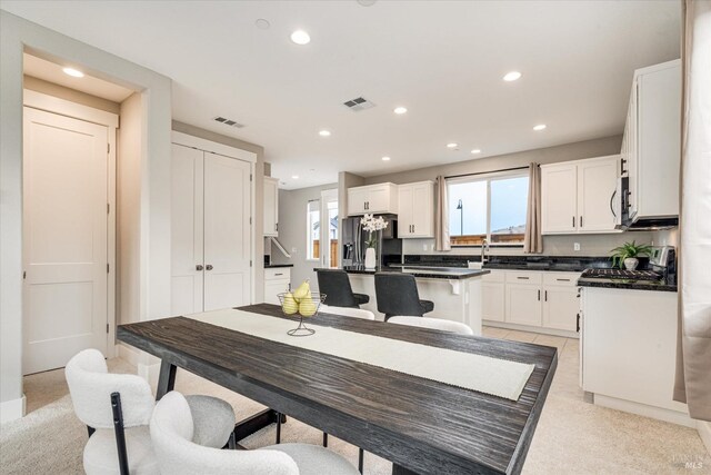 living room featuring baseboards, recessed lighting, visible vents, and light carpet