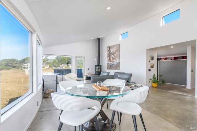 dining space featuring a wood stove and lofted ceiling