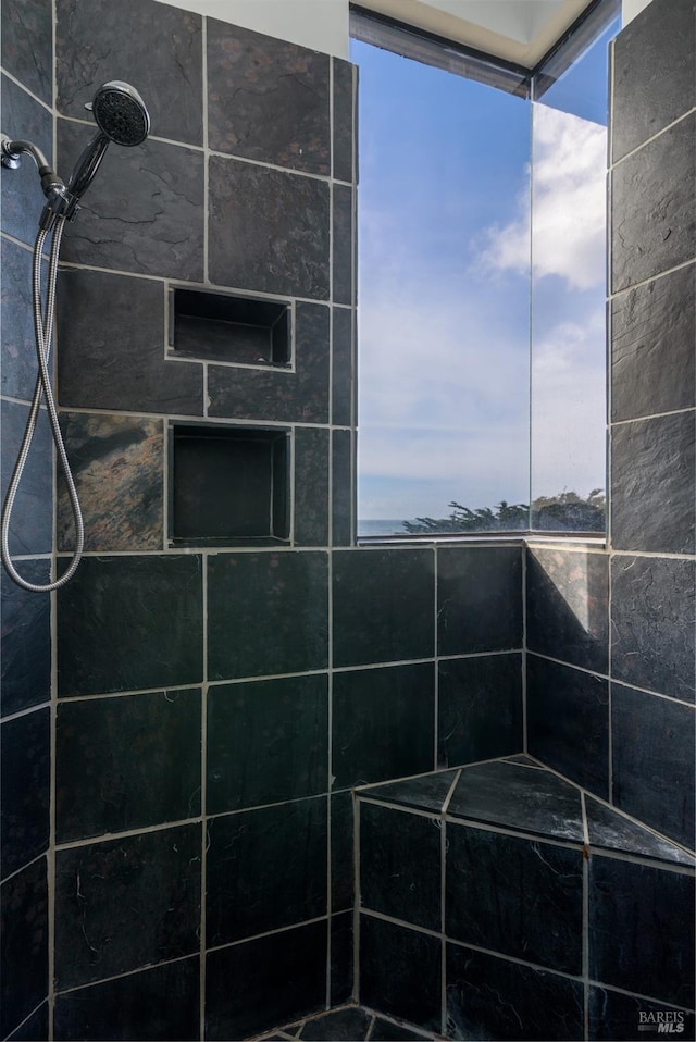 bathroom featuring tiled shower and a wealth of natural light