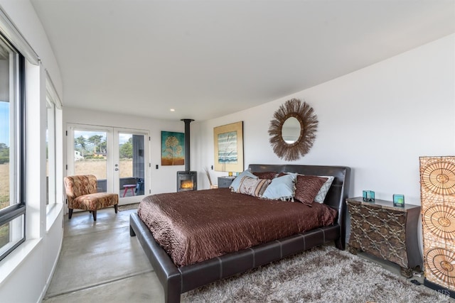 bedroom featuring a wood stove, access to outside, and french doors