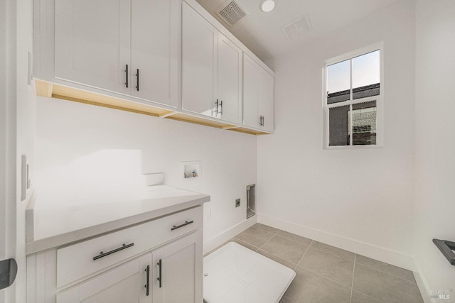 laundry room featuring hookup for a washing machine, light tile patterned floors, cabinets, and hookup for an electric dryer