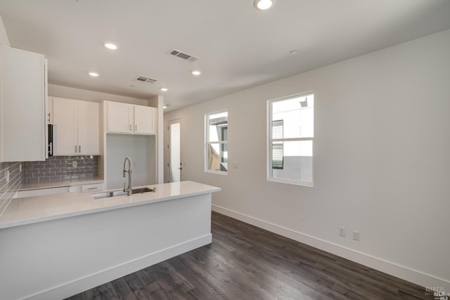 kitchen featuring white cabinets, backsplash, dark hardwood / wood-style flooring, and sink