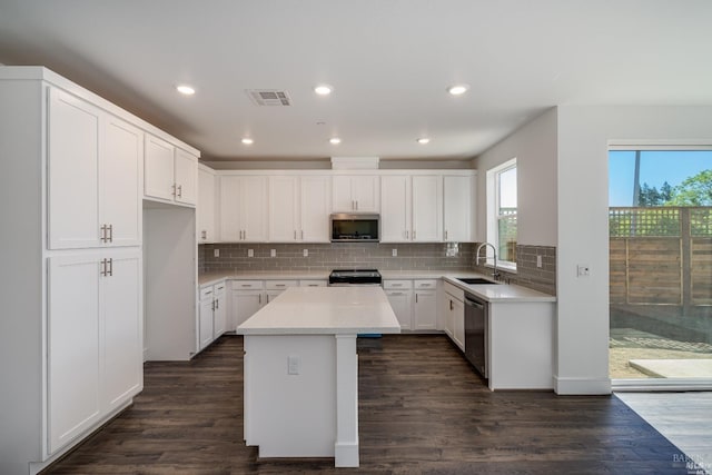 kitchen featuring a center island, white cabinets, sink, appliances with stainless steel finishes, and dark hardwood / wood-style flooring