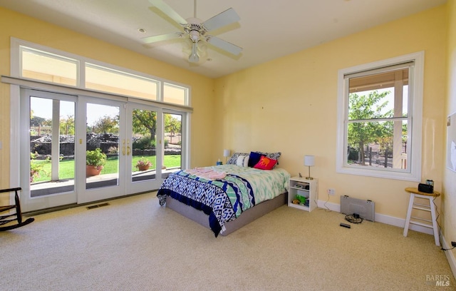 bedroom with multiple windows, access to outside, ceiling fan, and carpet