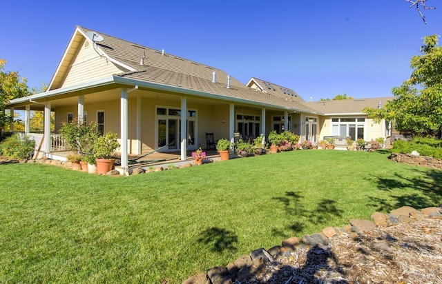 back of house with a patio area and a lawn