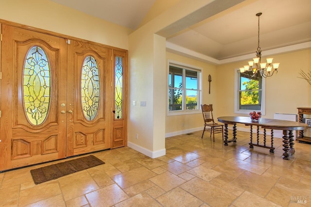 entrance foyer featuring a tray ceiling and a chandelier