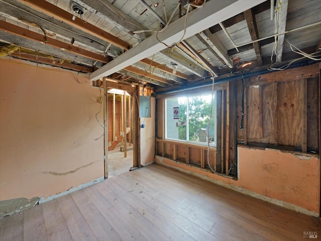 basement featuring light hardwood / wood-style floors and electric panel