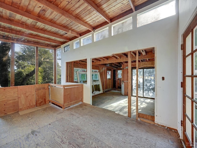 unfurnished sunroom featuring beamed ceiling and wood ceiling