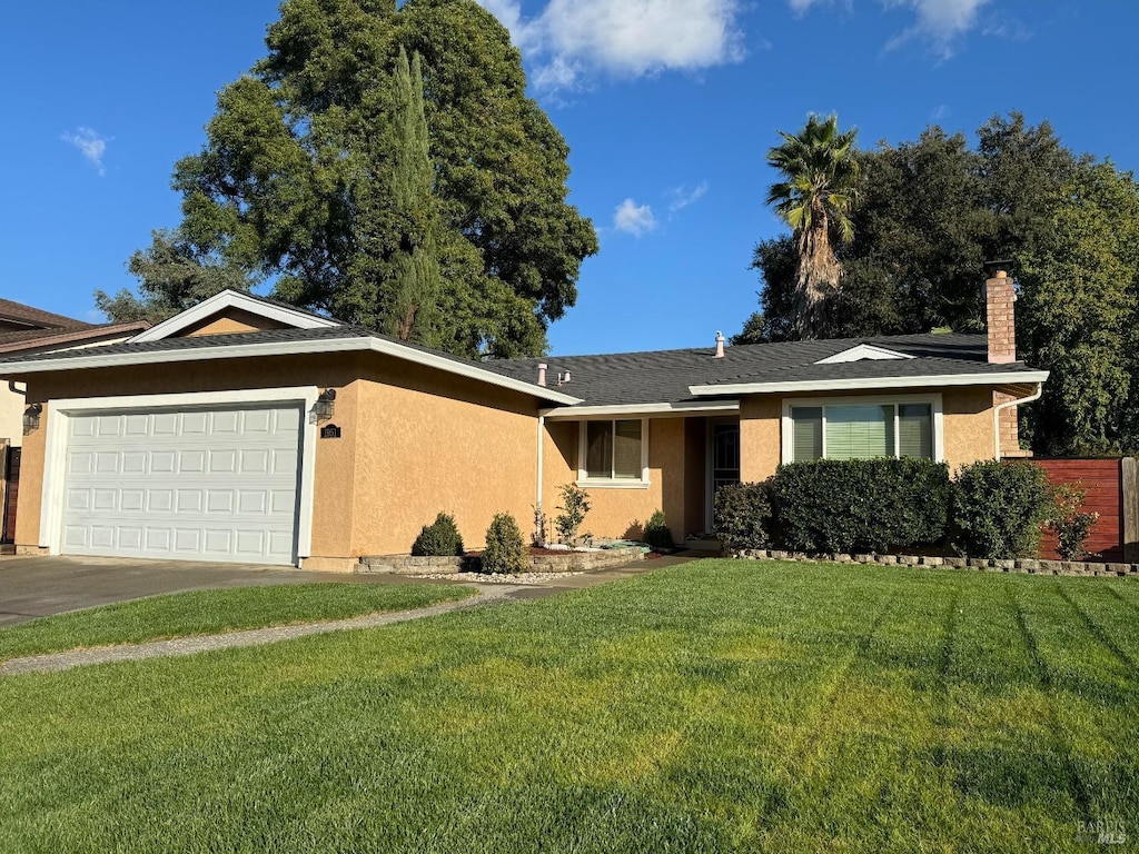 ranch-style home with an attached garage, stucco siding, and a front yard