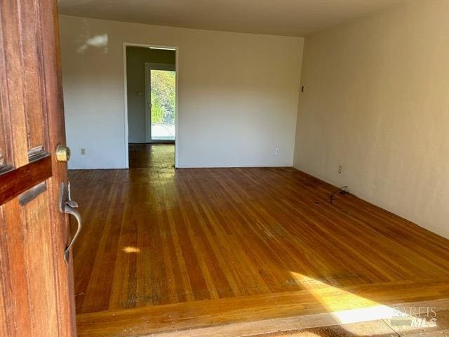 empty room with dark wood-type flooring