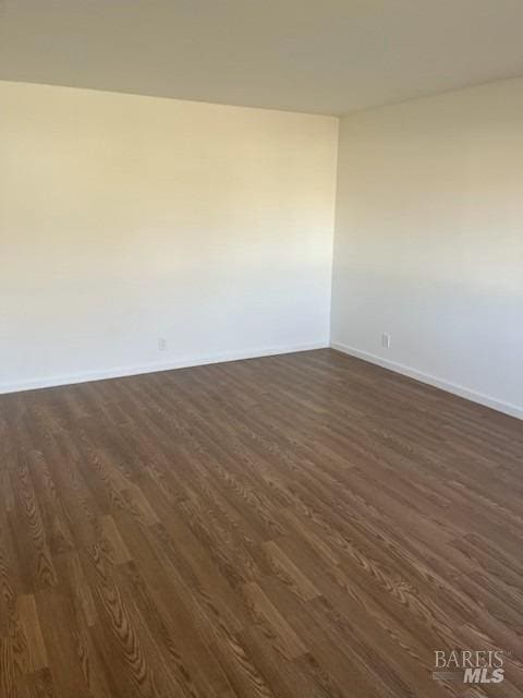 empty room with dark hardwood / wood-style flooring