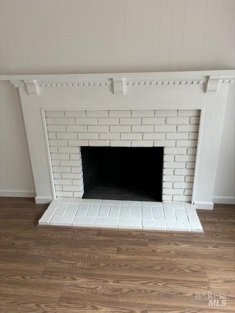interior details with baseboards, wood finished floors, and a fireplace