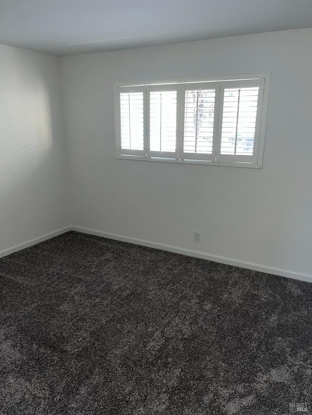 carpeted empty room with baseboards