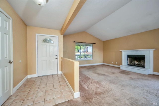 carpeted entrance foyer featuring lofted ceiling and a brick fireplace