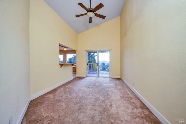 spare room featuring carpet flooring, high vaulted ceiling, and ceiling fan