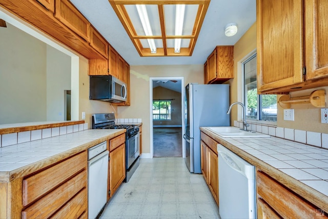 kitchen featuring tile countertops, sink, and stainless steel appliances