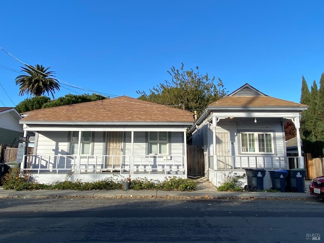 view of front of house featuring covered porch and fence