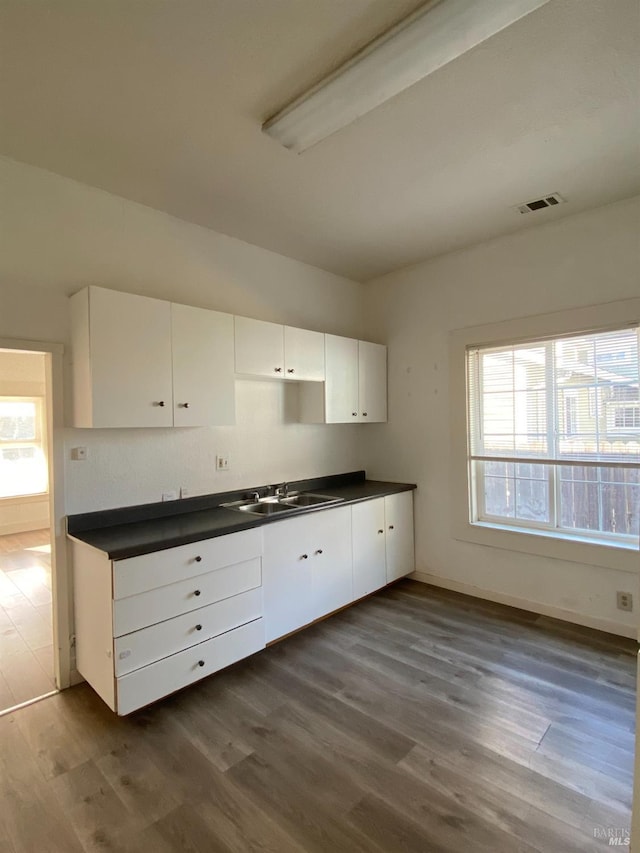 kitchen with white cabinetry, dark countertops, and dark wood-style floors