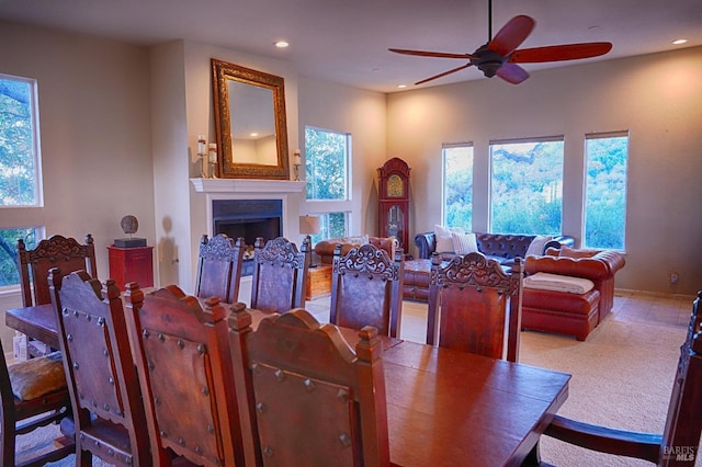 dining room featuring light carpet, ceiling fan, and a healthy amount of sunlight