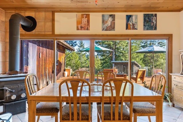 tiled dining area featuring a wood stove and wooden ceiling