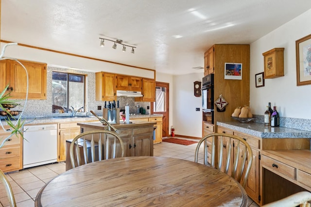 dining space with light tile patterned floors, sink, a wealth of natural light, and track lighting