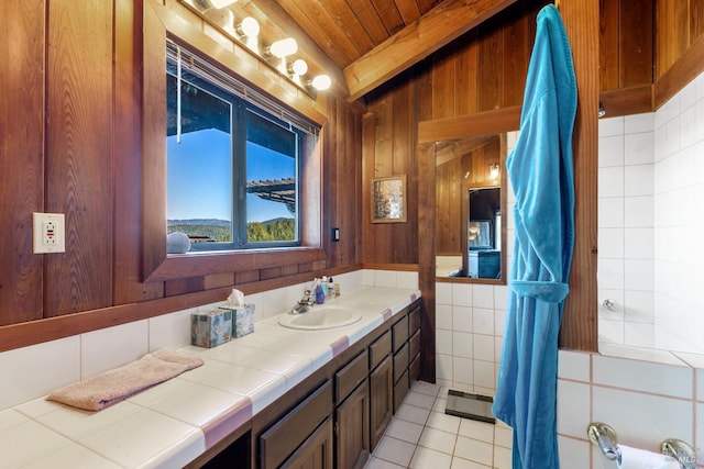 bathroom featuring wood ceiling, vanity, tile walls, tile patterned flooring, and vaulted ceiling with beams