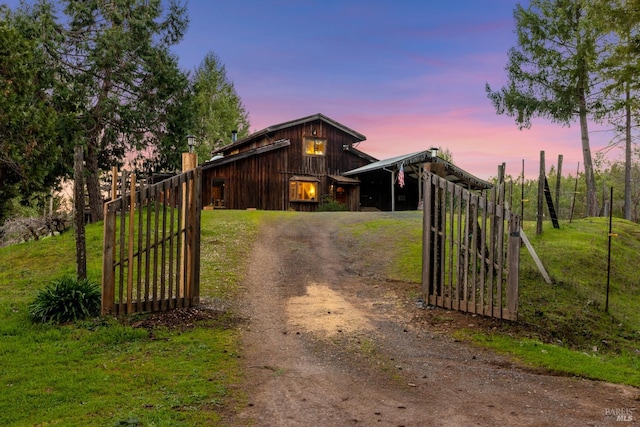 gate at dusk featuring an outbuilding