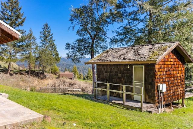 view of outdoor structure featuring a lawn and a mountain view