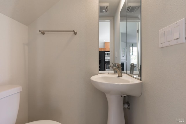 bathroom with vaulted ceiling and toilet