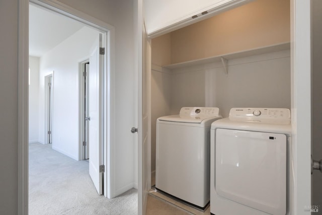 laundry room featuring separate washer and dryer and light carpet