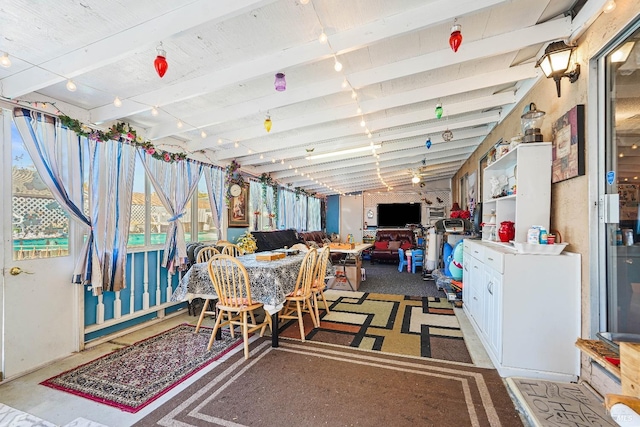 dining space featuring lofted ceiling with beams