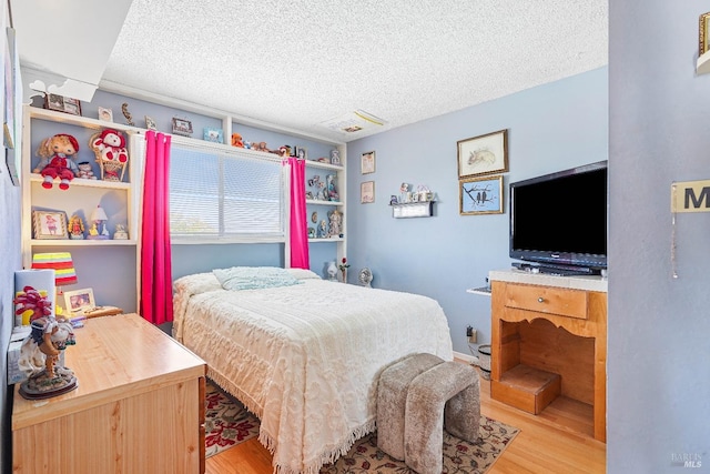 bedroom with hardwood / wood-style flooring and a textured ceiling