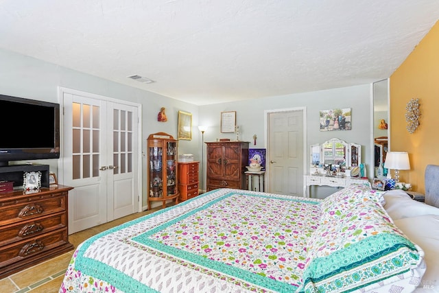 bedroom featuring a textured ceiling and french doors