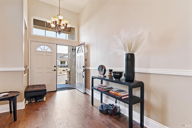 entryway featuring hardwood / wood-style floors, a notable chandelier, and a high ceiling