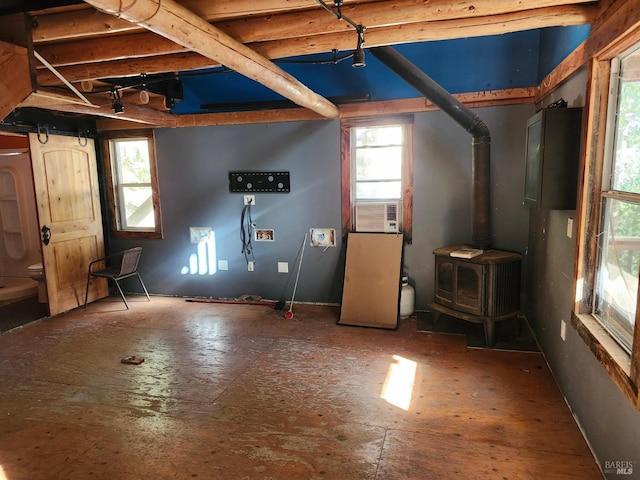 interior space with a wood stove, cooling unit, and a healthy amount of sunlight