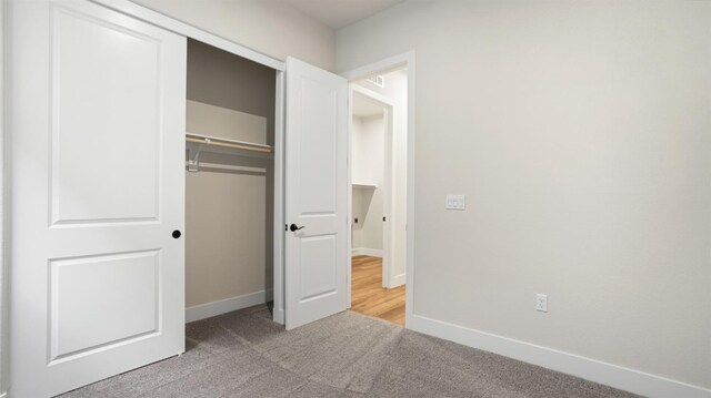 unfurnished bedroom featuring carpet flooring and a closet