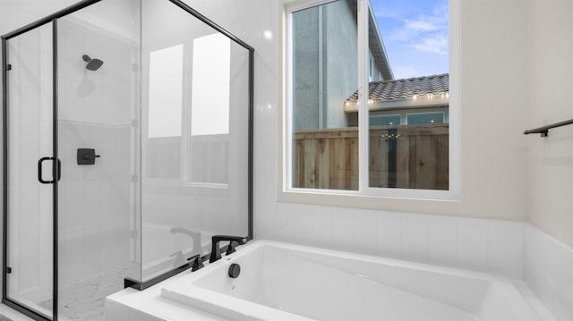 bathroom featuring shower with separate bathtub