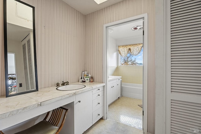 bathroom featuring a bathing tub, tile patterned flooring, and vanity